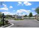 Community entrance gate featuring manicured landscaping and wrought iron fencing on a bright, sunny day at 8511 White Poplar Dr, Riverview, FL 33578