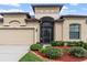 Stunning home with an elegant entryway, manicured shrubbery, and a convenient three-car garage at 8511 White Poplar Dr, Riverview, FL 33578