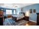 Spacious main bedroom featuring hardwood floors, a ceiling fan, a large window, and stylish decor at 8511 White Poplar Dr, Riverview, FL 33578