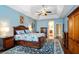 Comfortable main bedroom with wood floors, a tray ceiling, a ceiling fan, and access to the en-suite bathroom at 8511 White Poplar Dr, Riverview, FL 33578