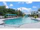 Resort-style community swimming pool featuring a splash zone, waterslide, lounge seating, and shaded areas at 8511 White Poplar Dr, Riverview, FL 33578