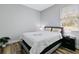 Cozy bedroom features a comfortable bed with white linens, a nightstand, and a window with natural light at 9149 Willmington Blvd, Englewood, FL 34224