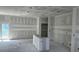 An unfinished living area with a large window and door, concrete floors, and unfinished walls and ceiling at 9149 Willmington Blvd, Englewood, FL 34224