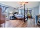 Spacious bedroom featuring a four-poster bed, wood floors, and ample natural light at 9712 White Barn Way, Riverview, FL 33569