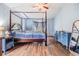 Cozy bedroom featuring a four-poster bed, wood floors, and bay windows at 9712 White Barn Way, Riverview, FL 33569