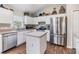 Well-lit kitchen with stainless steel appliances, white cabinetry, and a center island at 9712 White Barn Way, Riverview, FL 33569