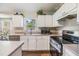 Spacious kitchen featuring a breakfast bar, stainless steel appliances, and wood-look flooring at 9712 White Barn Way, Riverview, FL 33569