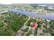 Aerial view showcases a single-Gathering home surrounded by lush trees, marked with a red arrow at 9908 Alafia River Ln, Gibsonton, FL 33534