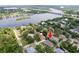 Aerial shot of a waterfront property with mature trees, featuring the house with a red arrow indicator at 9908 Alafia River Ln, Gibsonton, FL 33534