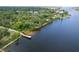 Scenic aerial view of waterfront property showcasing the dock and lush greenery at 9908 Alafia River Ln, Gibsonton, FL 33534