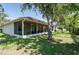 This backyard has a screened patio, mature trees, and a privacy fence at 9908 Alafia River Ln, Gibsonton, FL 33534