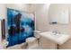 This bathroom features a pedestal sink, a toilet, and a shower with a decorative curtain at 9908 Alafia River Ln, Gibsonton, FL 33534