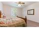 Comfortable bedroom with a ceiling fan, large window and carpeted floors at 9908 Alafia River Ln, Gibsonton, FL 33534