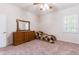 Bedroom with wood dresser and furnishings, carpeted floor and bright window at 9908 Alafia River Ln, Gibsonton, FL 33534