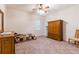 Cozy bedroom with carpet, window with shutters, and wooden furniture at 9908 Alafia River Ln, Gibsonton, FL 33534