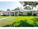 Attractive single-story home with a lush green lawn, landscaped yard, and inviting walkway to the front entrance at 9908 Alafia River Ln, Gibsonton, FL 33534