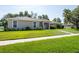 Inviting single-story home featuring a lush green lawn and well-maintained landscaping at 9908 Alafia River Ln, Gibsonton, FL 33534