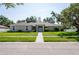 Charming single-story home with a well-manicured lawn and inviting entryway with double doors at 9908 Alafia River Ln, Gibsonton, FL 33534