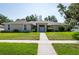 Charming single-story home featuring a well-manicured lawn and inviting entryway at 9908 Alafia River Ln, Gibsonton, FL 33534