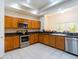 Well-lit kitchen with stainless steel appliances, granite countertops, and lots of cabinet space for storage at 9908 Alafia River Ln, Gibsonton, FL 33534