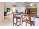Open kitchen with wood cabinets, granite countertops, and two barstools at 9908 Alafia River Ln, Gibsonton, FL 33534