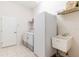 This laundry room features a washing machine, dryer, spare fridge, sink and storage shelf at 9908 Alafia River Ln, Gibsonton, FL 33534