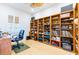 Bright home office with a large built-in bookshelf, bamboo floors, and a comfortable desk setup at 9908 Alafia River Ln, Gibsonton, FL 33534