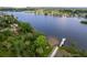 An aerial view captures the serene waterfront, highlighting a private dock, and lush vegetation at 9908 Alafia River Ln, Gibsonton, FL 33534