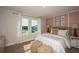 Bright bedroom with large windows, plush cushions, and floral artwork creating a cozy and inviting retreat at 9941 Surrey Rose Dr, San Antonio, FL 33576