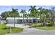 Charming single-story home with a well-manicured lawn and driveway, surrounded by tall palm trees at 10011 46Th W Ave, Bradenton, FL 34210