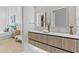 Stylish bathroom with double sink vanity, modern mirrors, and view into bedroom at 1020 Sunset Point Rd # 712, Clearwater, FL 33755