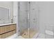 Modern bathroom with wood vanity, glass-enclosed shower, and marble tile at 1020 Sunset Point Rd # 712, Clearwater, FL 33755
