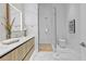 Sleek bathroom featuring wood vanity, glass-enclosed shower, and marble tile accents at 1020 Sunset Point Rd # 712, Clearwater, FL 33755