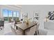 Bright, open dining room area with modern table, chairs, and waterfront views at 1020 Sunset Point Rd # 712, Clearwater, FL 33755