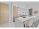 Contemporary kitchen with sleek white cabinetry, waterfall island, counter seating, and natural wood accents at 1020 Sunset Point Rd # 712, Clearwater, FL 33755