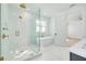 Bright bathroom featuring glass shower, freestanding tub, and gold fixtures with white tile and flooring at 1201 35Th N Ave, St Petersburg, FL 33704