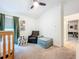 Bedroom with crib, comfortable chair and footstool, closet, and ceiling fan at 12010 Jackson Landing Pl, Tampa, FL 33624