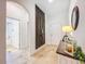 Hallway featuring wood floors, console table, and a doorway to a tiled bathroom with shower at 12010 Jackson Landing Pl, Tampa, FL 33624