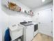 Well-organized laundry room with modern washer and dryer, sink, and shelving at 12010 Jackson Landing Pl, Tampa, FL 33624