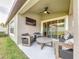 Covered patio with ceiling fan, tv, and furniture creates the perfect outdoor living space at 12010 Jackson Landing Pl, Tampa, FL 33624