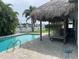 Backyard featuring a tiki bar, pool, and waterfront views at 12055 4Th E St, Treasure Island, FL 33706