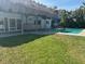 Outdoor oasis with a pool, covered lanai, and lush green lawn, ideal for relaxation and entertainment at 12055 4Th E St, Treasure Island, FL 33706