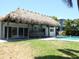 A covered outdoor bar area looks out onto a sparkling pool and backyard space at 12055 4Th E St, Treasure Island, FL 33706