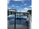 Boat dock and lift on the calm open water behind the property with a sunny sky at 12055 4Th E St, Treasure Island, FL 33706
