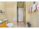 Cozy bathroom featuring warm, vintage wallpaper, and a white toilet at 1212 Baycove Ln, Lutz, FL 33549