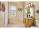 Cozy bathroom featuring warm, vintage wallpaper, window, and traditional vanity at 1212 Baycove Ln, Lutz, FL 33549