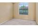 Bright bedroom with neutral carpet and a window overlooking the front yard at 1212 Baycove Ln, Lutz, FL 33549