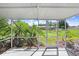 Relaxing screened-in lanai offering views of lush backyard landscaping and blue skies at 1212 Baycove Ln, Lutz, FL 33549
