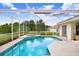 A sparkling pool with screened enclosure, and an adjacent patio area at 1212 Baycove Ln, Lutz, FL 33549