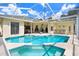 A sparkling pool with screened enclosure, and an adjacent patio area with furniture at 1212 Baycove Ln, Lutz, FL 33549